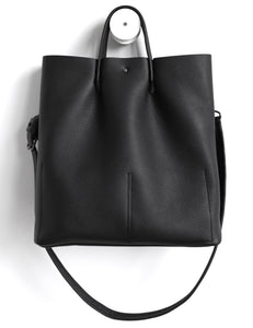 Monday frrry tote bag. shoulder strap. black. back view. button closure