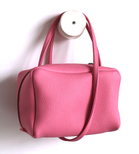 Tuesday. small frrry bag. shoulder bag. hand-held-bag. evening bag. thin strap. zipper closure. pink colour.