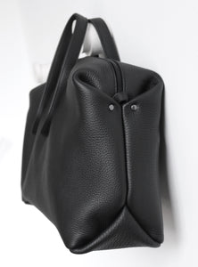 Wednesday frrry bag. black. side view. angry face. unintentional faces.